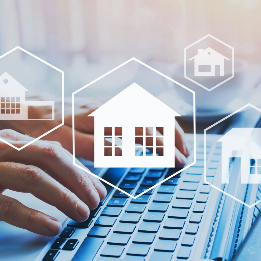 Person using a laptop with house and property icons, symbolizing government property management solutions for public agencies in 2025.